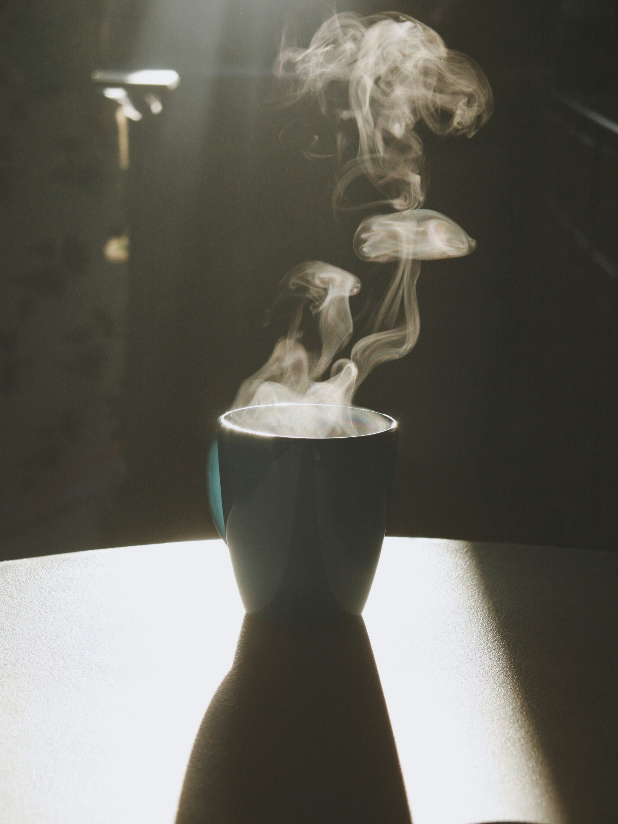 Steam rising from a cup in low light